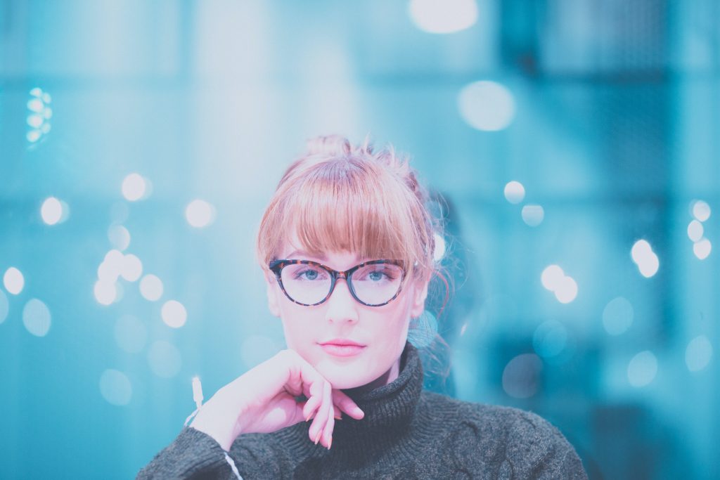 woman in glasses with blury blue background