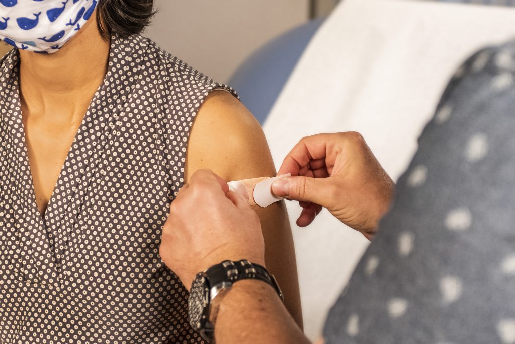 bandaid being applied to woman's arm