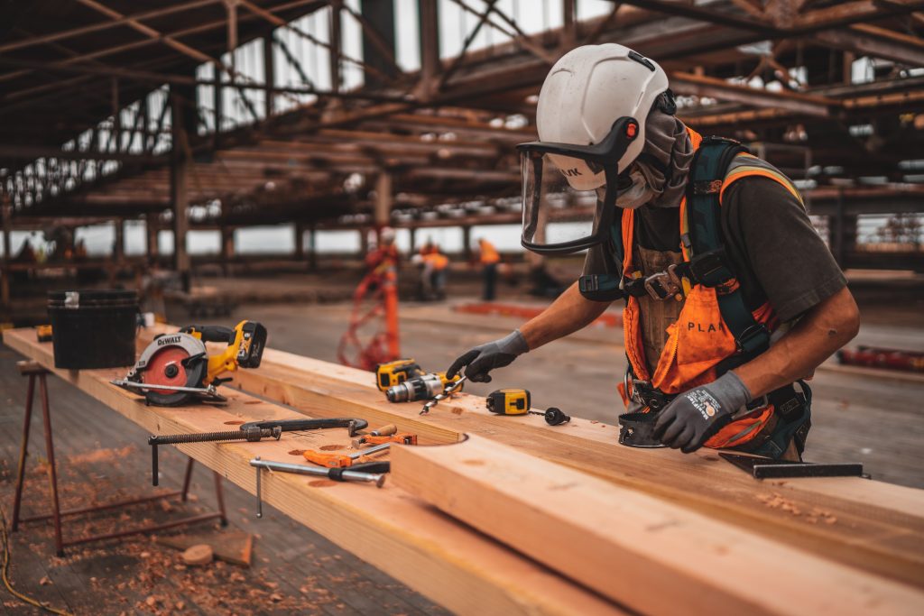 worker with power tools and lumber