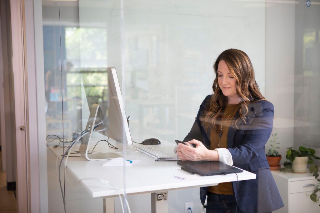 worker at stand up desk on phone
