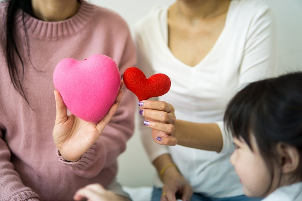 women holding stuffed hearts