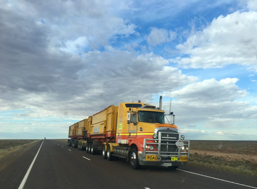 tractor trailer on open road with open sky background