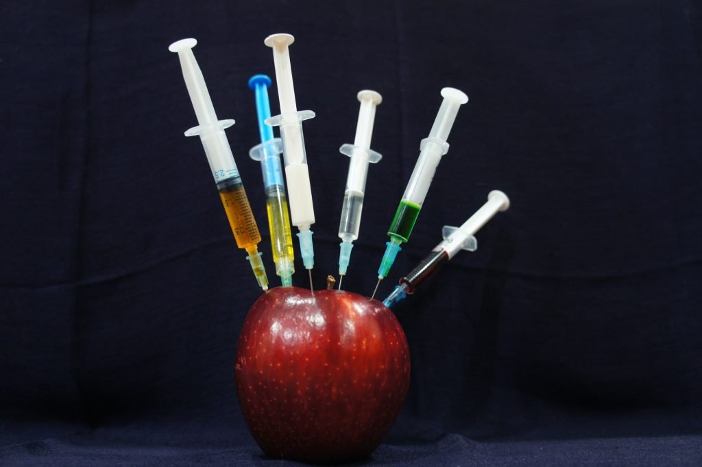 six syringes in an apple