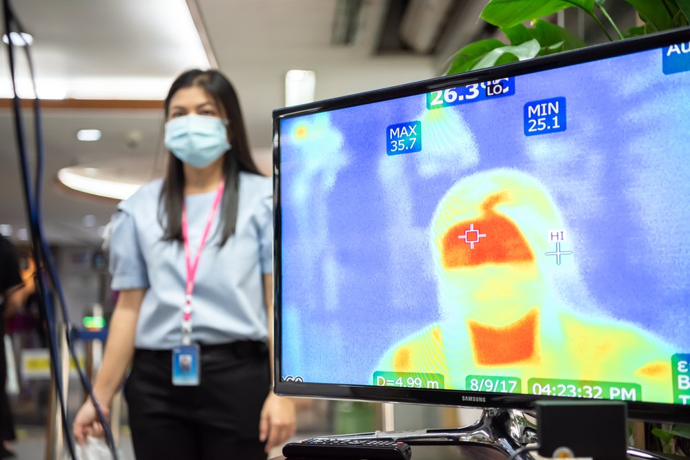 woman standing next to thermographic screen