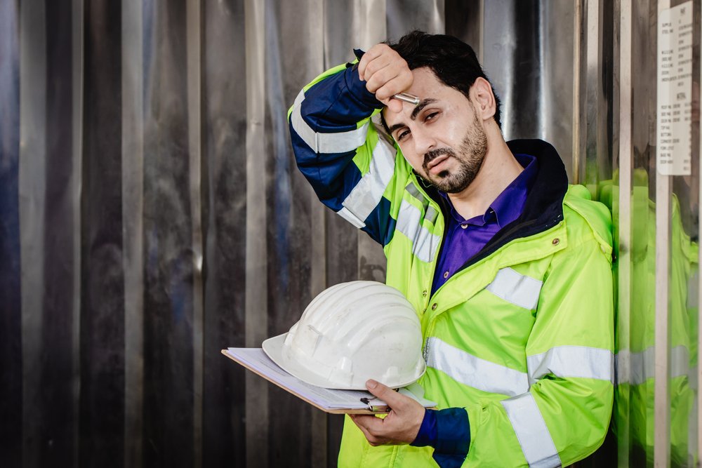tired worker wiht hard hat in hot conditions