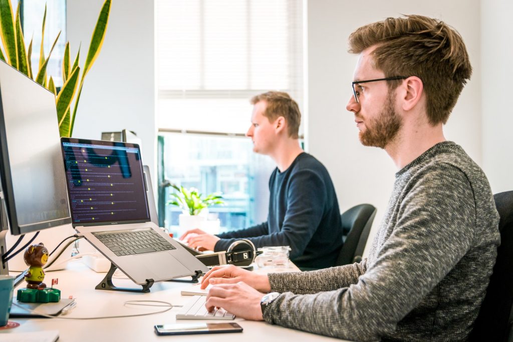 two workers at desk on computers