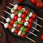 caprese-skewers-with-tomatoes-mozzarella-balls-basil-spices-wooden-table-flat-lay_1339860-3260