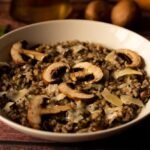 mushroom-risotto-italian-food-known-as-risotto-ai-funghi-closeup-with-warm-light-parsley-side_1048944-937229