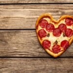 pizza-shape-heart-wooden-table_156140-408