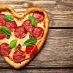 pizza-shape-heart-wooden-table_156140-411