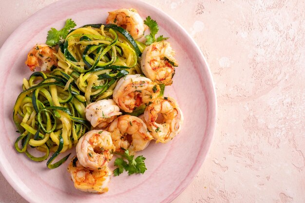 zucchini-pasta-with-shrimps-white-plate_255424-3387